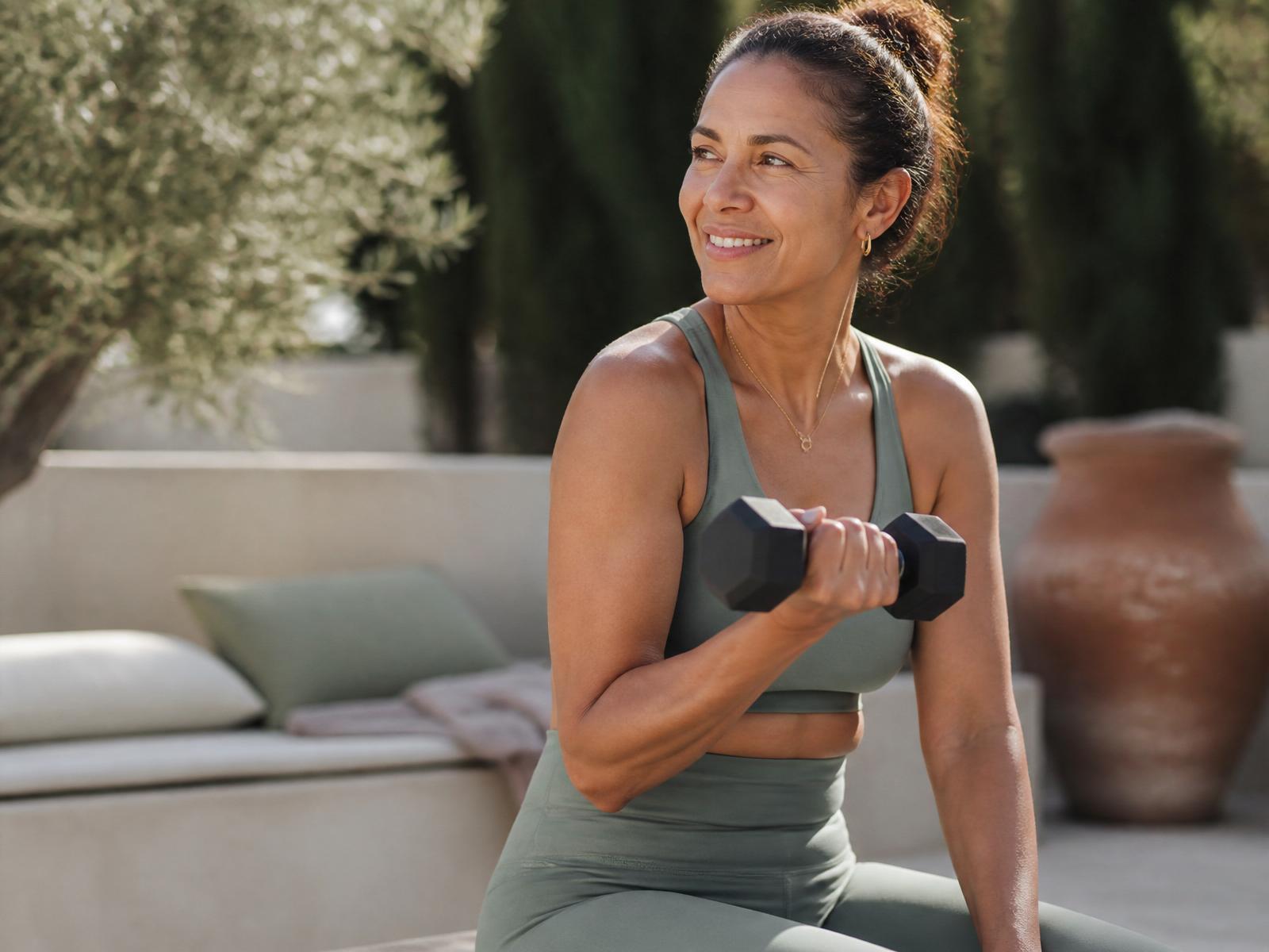 Andrea coaching a woman through gentle strength training in soft morning light