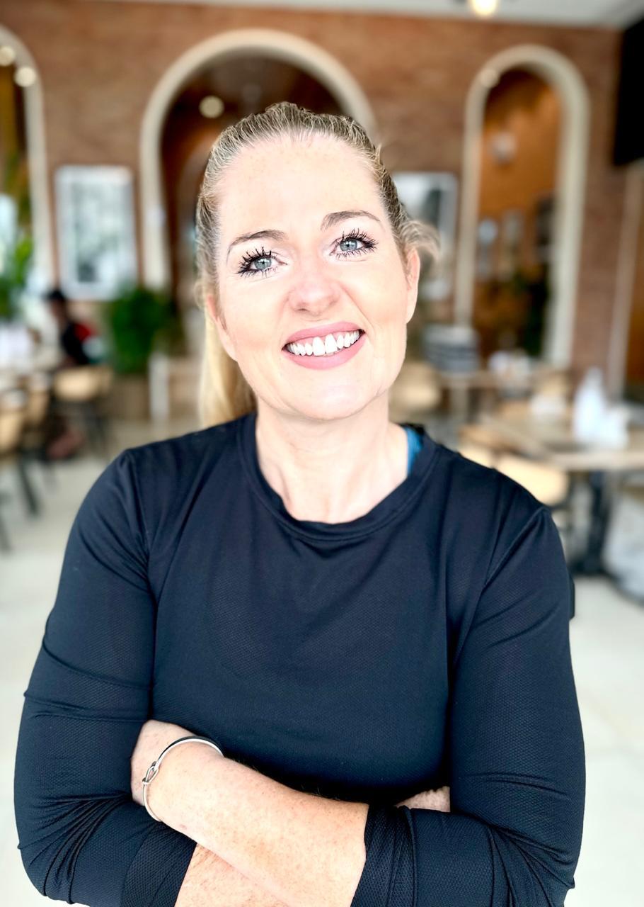 Andrea Dowds, fitness, healthy-eating and menopause coach, smiling with arms folded